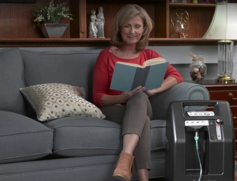 Woman with oxygen concentrator reading book