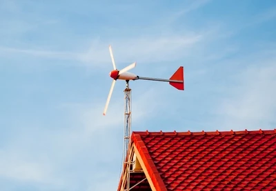 Malá domácí větrná elektrárna na střeše domu.