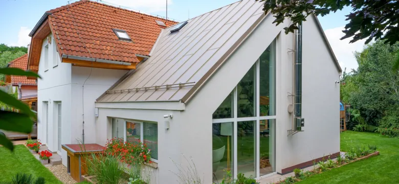 Modernizovaný rodinný dům s velkými okny a zahradou po rekonstrukci.