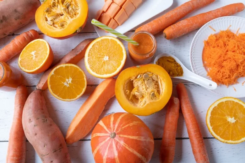 Čerstvá mrkev, pomeranče a další oranžová zelenina bohatá na beta karoten.