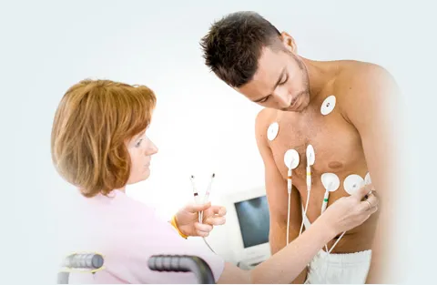 Lékař připojuje elektrody k hrudi pacienta pro záznam EKG.