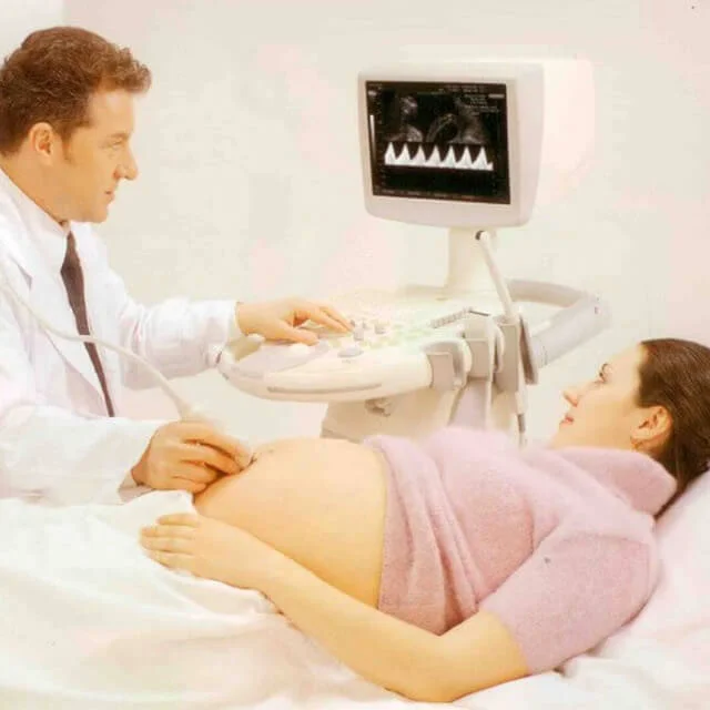 Lékař provádí ultrazvukové vyšetření těhotné ženy.