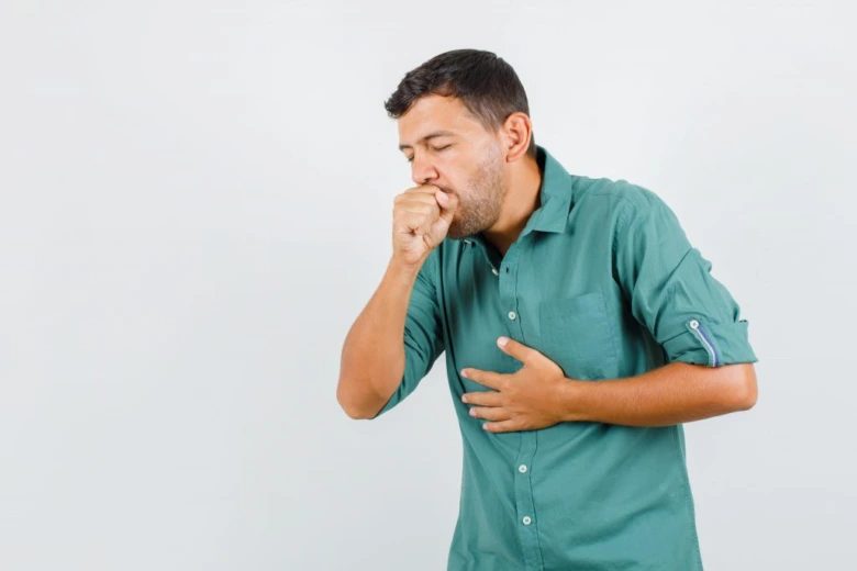 Man coughing into hand