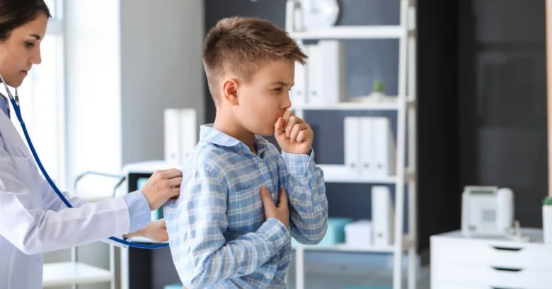 Doctor examining boy with asthma symptoms