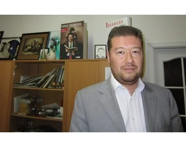 Tomio Okamura v kanceláři s knihami o něm na polici.