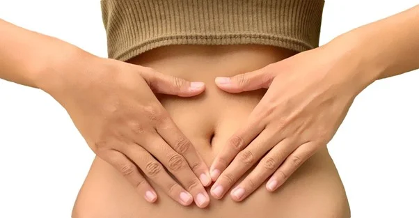 Ruce na břiše ukazující bolest při zánětu střev.