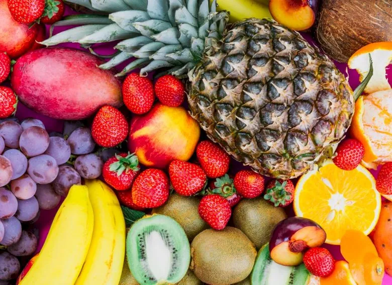 Různé čerstvé ovoce jako jahody, banány, ananas a hroznové.