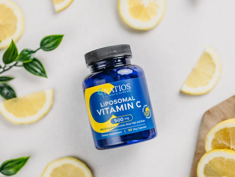 Modrá lahvička s vitamínem C obklopená kousky citrony.