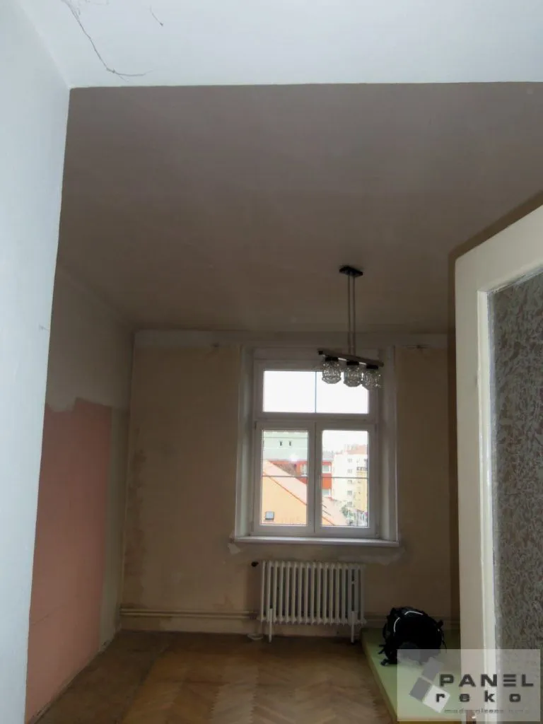 Prázdný byt v Praze během rekonstrukce s odhalenými stěnami