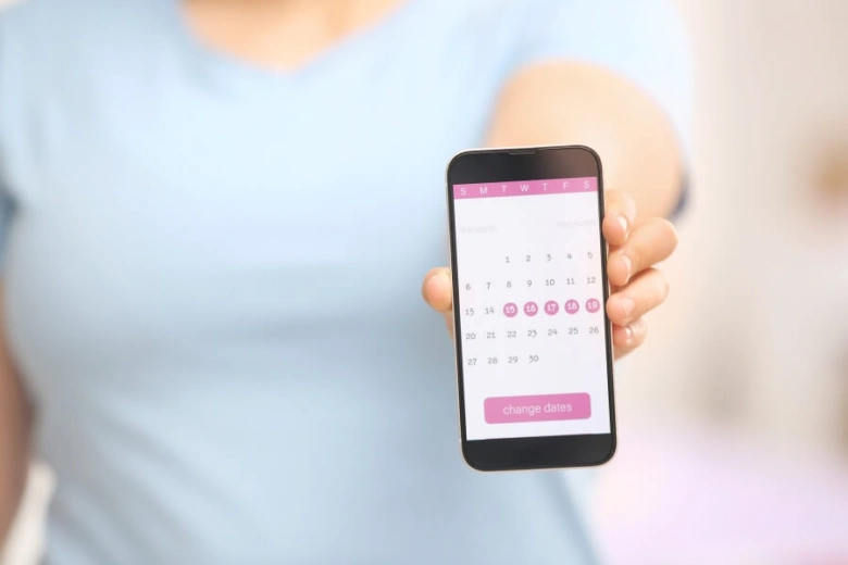 Telefon s aplikací pro sledování menstruačního cyklu.