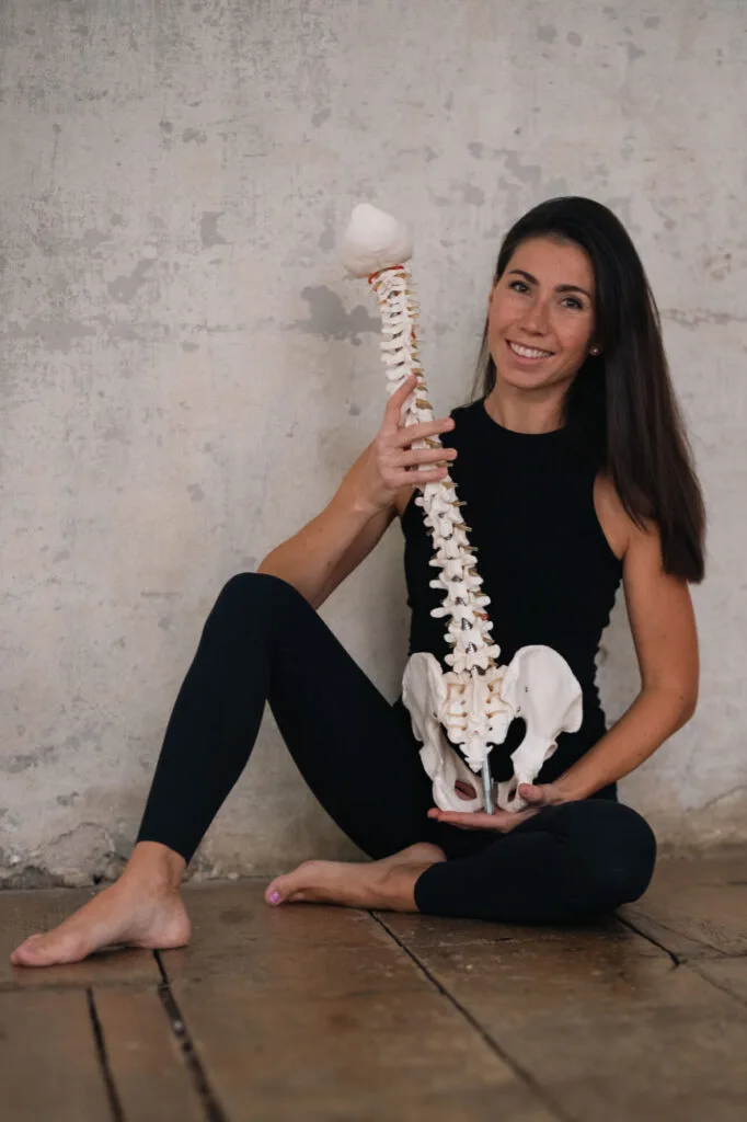 Žena drží model páteře s panvemi pro cvičení na pánevní dno.