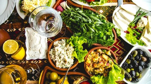 Stůl s mediterránskými protizánětlivými potravinami jako jsou olive a zelenina
