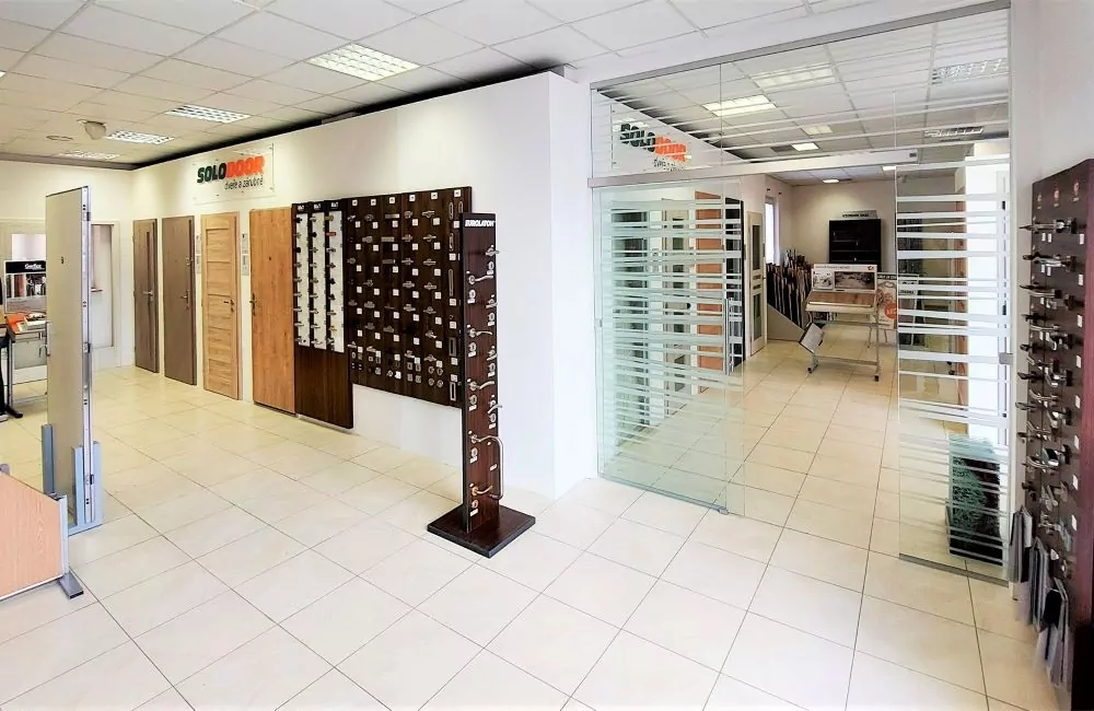 Výstava bezpečnostních dveří s náhledy na různé modely v obchodě.