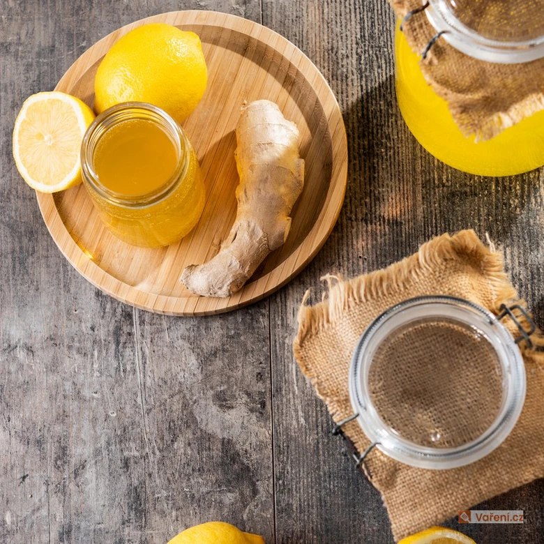 Žlutá citronová nápoj s ingrem na dřevěném podnosu