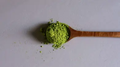 Dřevěná lžička s jemným zeleným práškem z čaje Matcha.