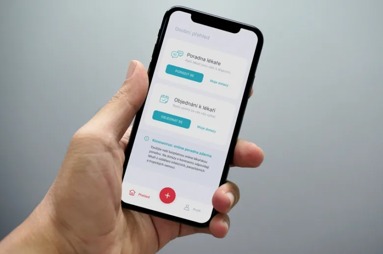 Ruka drží mobil s aplikací pro online lékařskou poradnu.