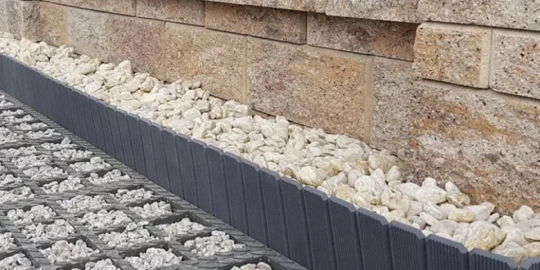 Detail základy opěrné zdi s kamínky na svahu