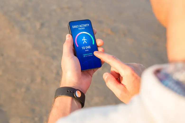 Smartfon s aplikací počítající kroky pro sledování denní aktivity.
