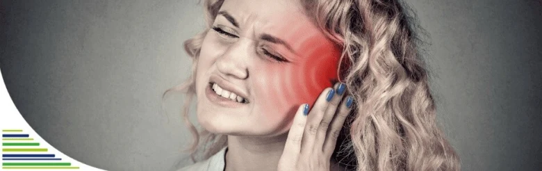 Žena s bolestí ucha drží si ruku k bolavému uchu.