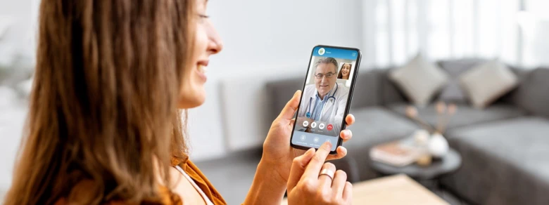 Žena telefonuje s lékařem přes mobilní aplikaci pro teleporadnu.