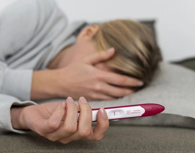 Žena drží těhotenský test s jedním proužkem ukazuje negativní výsledek.