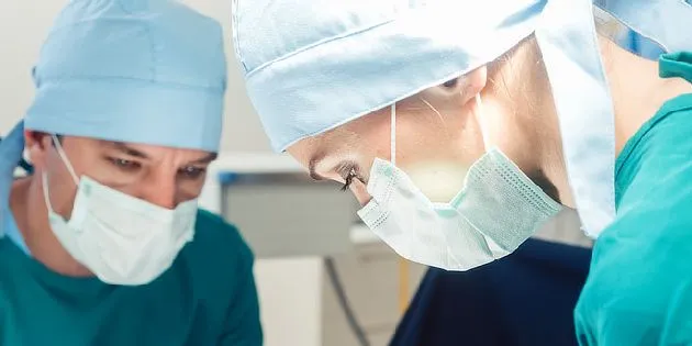 Dva chirurgové v operačním sále během operace.