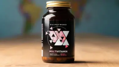 Fialová lahvička s ženským komplexem vitamínů BrainMax na dřevěném stole.