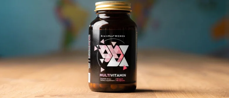 Fialová lahvička s ženským komplexem vitamínů BrainMax na dřevěném stole.