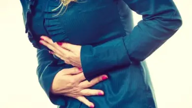 Žena drží břicho v bolesti při samovolném potratu.