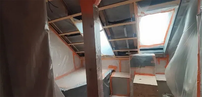 Stříkaná izolace v prostoru s ochranným pláštěm a odhalenou konstrukcí.