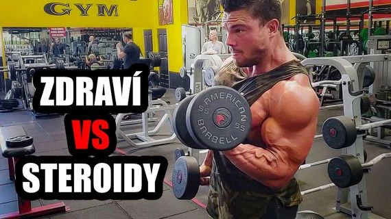 Muž v posilovně zvedá činku s nápisem zdraví vs steroidy