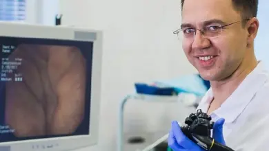 Lékař s endoskopem u monitoru zobrazujícího tlustý střevo.