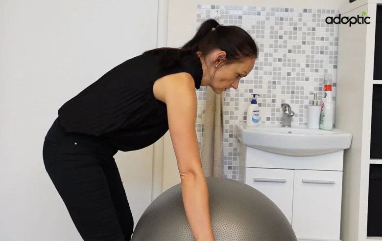 Žena cvičí s fitballem pro úlevu od bolesti zad.