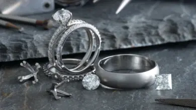 Platinové snubní prsteně s diamanty na tmavém kamenném povrchu.