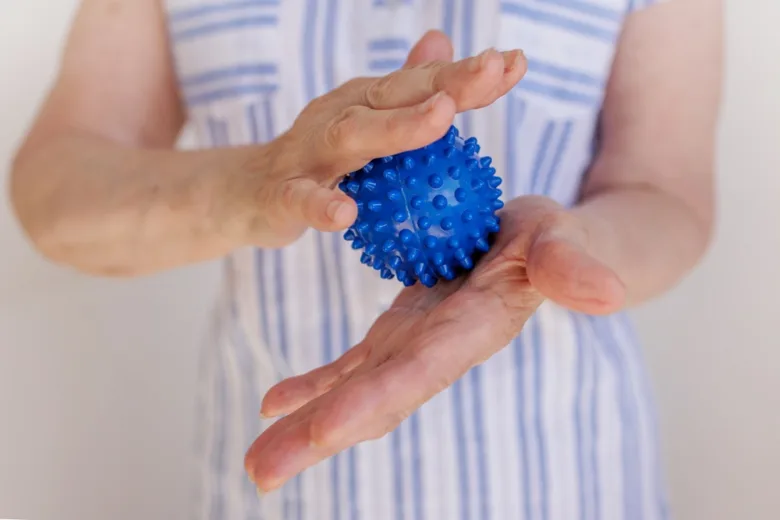 Ruční cvičení s modrým masážním míčkem pro parkinson