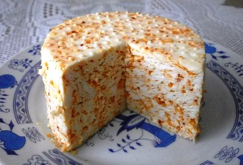 Kousek čerstvého sýra na talíři ukazuje jeho vnitřní strukturu a texturu.